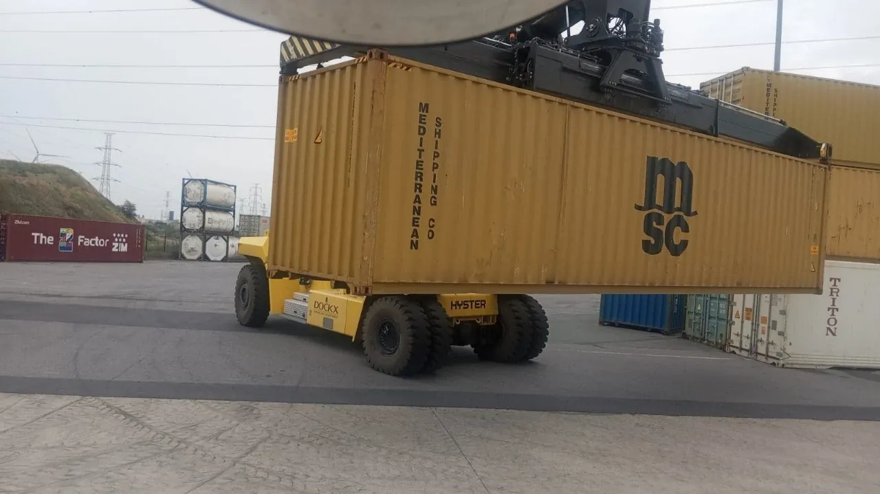 A reach stacker lifting a 40ft container at the port terminal
